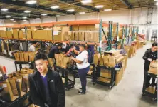  ?? Michael Macor / The Chronicle 2017 ?? Workers fill orders at the Amazon Prime Now center in San Francisco. Warehouse fulfillmen­t roles are among jobs where there are many openings.