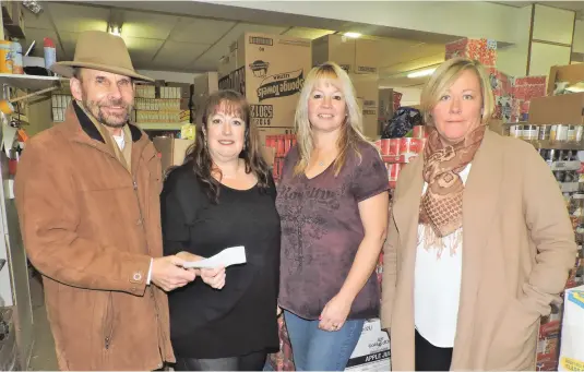  ??  ?? Realtor Wally Meili presents a cheque to Deann Little and Terri Smith of the Moose Jaw and District Food Bank. Also pictured is Realtor Jamie Jackson (right).