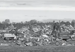  ?? SCOTT UTTERBACK/USA TODAY NETWORK ?? People look around the candle factory Saturday in Mayfield, Ky., where workers died when a tornado struck overnight Friday.