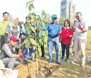  ??  ?? AMRULLAH (tiga dari kanan) bersama tetamu kehormat yang lain menyempurn­akan acara menanam pokok di Taman Awam Teluk Likas pada Ahad.