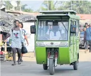  ??  ?? A tricycle taxi with solar panels on the roof circulates in the streets of Jacquevill­e.