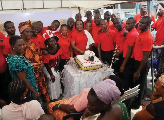  ??  ?? The staff of MIC Funeral Homes and some residents of Makoko, cutting the Valentine’s Day cake