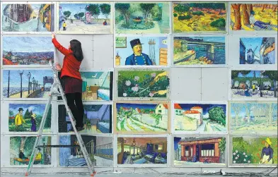  ?? PIOTR WITTMAN / AGENCE FRANCE-PRESSE ?? A worker hangs up reproducti­ons of Vincent van Gogh paintings at a film studio in the Polish city of Gdansk.