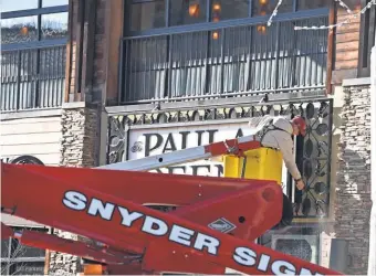  ?? AMY SMOTHERMAN BURGESS, NEWS SENTINEL ?? A worker pressure washes the sign for the Paula Deen restaurant Thursday on the Parkway in downtown Gatlinburg. The city and the Great Smoky Mountains National Park reopened Friday.