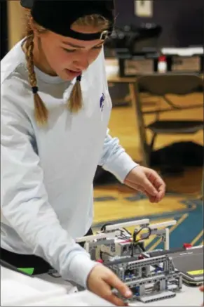  ?? KRISTI GARABRANDT — THE NEWS-HERALD ?? Anna, Hadzinski, 13, works on the robot for her team Don’t Hate, Meditate prior to team battles.