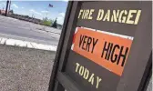  ?? PETER SCHWEPKER/THE REPUBLIC ?? A sign in East Flagstaff reminds residents of the fire danger as high winds blow a flag in the background.