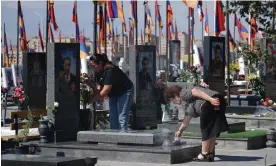  ?? Photograph: Christophe­r Cherry/The Guardian ?? Women laying flowers and lighting incense at a graveside at Yerevan military cemetery.