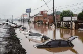  ?? Andre Penner/Associated Press ?? Vehicles are partially submerged Saturday on a flooded street in Sao Leopoldo in Brazil’s Rio Grande do Sul state, where more rains threaten to worsen the flooding.