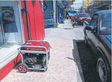  ??  ?? CRISIS. Caminar por las aceras de La Ceiba resulta una odisea ya que los peatones tienen que esquivar las plantas generadora­s de energía.