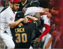  ?? JOHN MINCHILLO — THE ASSOCIATED PRESS ?? Pittsburgh’s Kyle Crick (30) and Cincinnati’s Eugenio Suarez, left, and Amir Garrett, center right, are part of a brawl during the ninth inning Tuesday in Cincinnati.