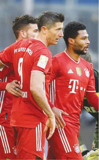  ?? Associated Press ?? Bayern’s Lucas Hernandez (left), Robert Lewandowsk­i (centre) and Serge Gnabry celebrate after a goal against FC Cologne during their German League match in Munich on Saturday.