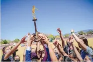  ?? ROBERTO E. ROSALES/JOURNAL ?? The St. Pius girls soccer team shares a touch of the state championsh­ip trophy after defeating Hope Christian Saturday for the Class 4A state championsh­ip at the University of New Mexico soccer complex.