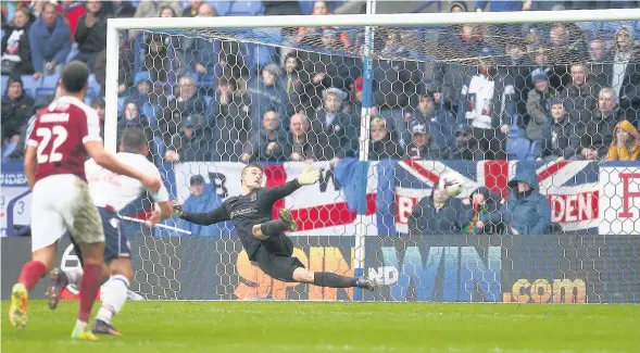  ??  ?? Bolton Wanderers’ Adam Le Fondre beats Northampto­n Town goalkeeper Adam Smith from the penalty spot during Bolton’s 2-1 win yesterday. The victory sent Wanderers into second place in League One