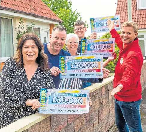  ?? ?? KNOCKING AT YOUR DOOR: Arbroath winners of the Postcode Lottery are handed their cheques by Jeff Brazier.