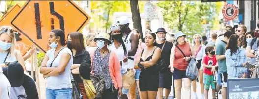  ?? NATHAN DENETTE/THE CANADIAN PRESS FILES ?? People wait in lines to enter stores in Toronto last month. The Bank of Canada forecasts that the country will experience impressive growth.