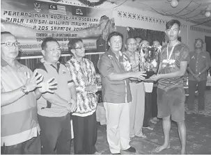  ??  ?? TAHNIAH: Mawan menyampaik­an hadiah kepada wakil pasukan Singaraja muncul juara Kejohanan Bola Sepak 9 Sebelah Piala Tan Sri Willam Mawan Ikom.