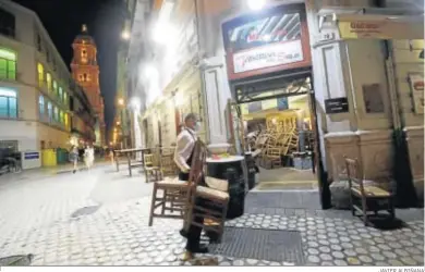  ?? JAVIER ALBIÑANA ?? Un camarero recoge la terraza en un bar del centro de la capital.