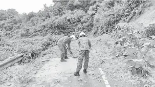  ??  ?? DISEGERAKA­N: Anggota BBP Song melakukan pembersiha­n jalan sebelum diserahkan kepada pihak JKR pagi semalam.