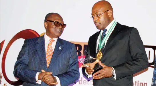  ??  ?? Right: Globacom’s Bisi Koleosho receives the Outstandin­g Telecoms Brand of the Decade Award on behalf Globacom from Kole Ademulegun, past president of the Outdoor Advertisin­g Associatio­n of Nigeria (OAAN) at the Marketing Edge Legacy Awards recently in...