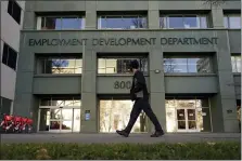  ?? RICH PEDRONCELL­I — THE ASSOCIATED PRESS FILE ?? In this Dec. 18, 2020, file photo, a person passes the office of the California Employment Developmen­t Department in Sacramento The recession that broke out with onset of the coronaviru­s pandemic officially ended in April 2021, making it the shortest downturn on record, according to the committee of economists that determines when recessions begin and end.