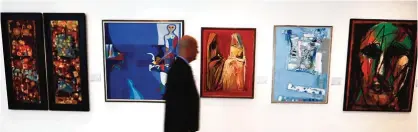  ??  ?? A visitor walks past art work by Iraqi painter Ismail Fatah Al-Turk.