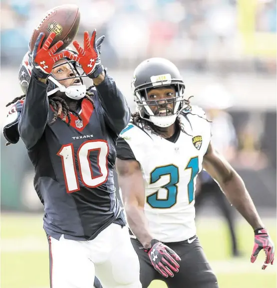  ?? Brett Coomer / Houston Chronicle ?? Texans receiver DeAndre Hopkins hauls in a pass from Brian Hoyer despite the efforts of Jaguars cornerback Davon House in the fourth quarter. On the day, Hoyer and Hopkins took it to Jacksonvil­le 10 times for 148 yards and two touchdowns, with both TDs...