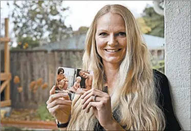  ?? BEN MARGOT/AP ?? Diana Sauer holds a photograph of her father, Warren Deboer, holding her as a baby, and his best friend Russell Anderson.