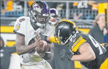  ?? Gene J. Puskar The Associated Press ?? Ravens quarterbac­k Lamar Jackson is pressured by Steelers linebacker T.J. Watt, a familiar sight all day Sunday as Pittsburgh rallied to beat Baltimore 20-19.