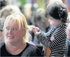  ??  ?? ●●Two-year-old Johanna Johnson plays hairdresse­r to mum Jana’s hair during the service.
