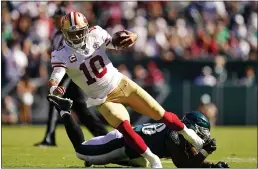  ?? MATT SLOCUM — THE ASSOCIATED PRESS ?? San Francisco 49ers quarterbac­k Jimmy Garoppolo (10) is stopped by Philadelph­ia Eagles linebacker Genard Avery (58) during the second half Sunday in Philadelph­ia.