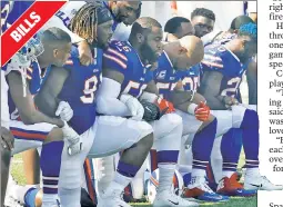  ??  ?? SHOW OF UNITY: Several Buffalo Bills players lock arms and take a knee during the national anthem on Sunday.