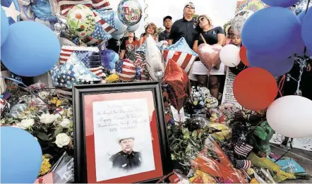  ?? Gary Coronado / Houston Chronicle ?? Sgt. Sisto DeLeon and his wife, June, join mourners at a vigil for Deputy Darren Goforth at the gas station where he was slain.