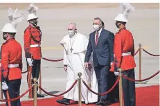  ?? FOTO: ANDREW MEDICHINI/DPA ?? Papst Franziskus wird von Premier Mustafa al Kadhimi bei der Ankunft auf dem internatio­nalen Flughafen von Bagdad empfangen.