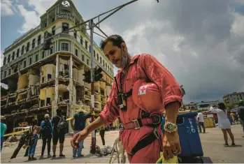  ?? RAMON ESPINOSA/AP ?? Havana hotel site: More bodies were pulled from the ruins of the Hotel Saratoga in Cuba’s capital Monday, bringing the death toll from an explosion to 35. Above, a member of the Cuban Red Cross takes a break after working in the rubble. The 96-room hotel was preparing to reopen after being closed for two years when an apparent gas leak ignited Friday.