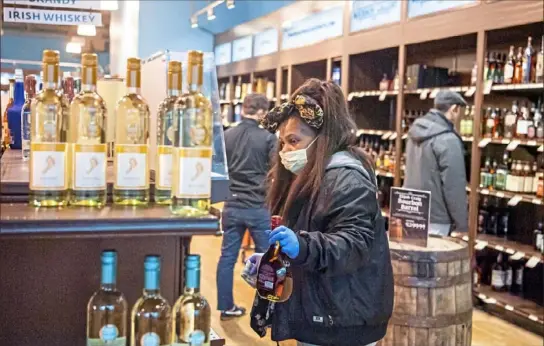  ?? Alexandra Wimley/Post-Gazette ?? Tammy Purcer, of Garfield, shops at the Fine Wine & Good Spirits store Sunday in East Liberty.