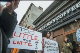  ?? MICHAEL BRYANT — THE PHILADELPH­IA INQUIRER VIA AP ?? Protesters gather outside of a Starbucks in Philadelph­ia, Sunday where two black men were arrested Thursday after employees called police to say the men were trespassin­g.