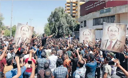  ?? Photo: REUTERS ?? Clinging to power: Supporters of Iraqi Prime Minister Nouri al-Maliki rally in Baghdad yesterday. Maliki is battling to keep his job, deploying forces across Baghdad as some parliament­ary allies sought a replacemen­t and the United States warned him not...