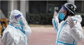  ?? ?? Protected: Pandemic prevention workers getting ready to enter an apartment amid outbreaks in Beijing. — Reuters