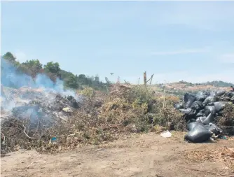  ??  ?? Plummets of smoke escape from multiple points underneath the refuse.