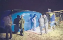  ?? MOSA’AB ELSHAMY/AP ?? Smugglers lift a fishing boat intended to carry migrants to the Canary Islands last month in a remote spot near the town of Dakhla in Western Sahara.