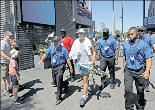  ??  ?? ESCOLTADO. Rafa Nadal se dirige a realizar un entrenamie­nto rodeado de personal de seguridad del Abierto de Estados Unidos.