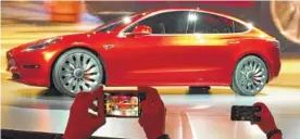  ?? ASSOCIATED PRESS FILE PHOTO ?? Tesla Motors unveils the new lower-priced Model 3 sedan at the Tesla Motors design studio in Hawthorne, Calif. Electric car maker Tesla said on Monday that its Model 3 car will go on sale on Friday.