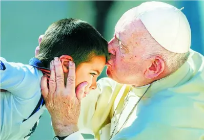  ?? AP ?? El Papa besa a un niño durante la Audiencia General de ayer en la Plaza de San Pedro