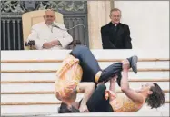  ??  ?? El papa Francisco observa un número acrobático durante la audiencia general de los miércoles, en la plaza de San Pedro en el Vaticano