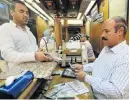  ?? Picture: REUTERS ?? FEELING THE PAIN: A customer exchanges US dollars for Egyptian pounds at a foreign exchange office in central Cairo