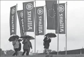  ?? MIGUEL VILLAGRAN / GETTY IMAGES ?? Pedestrian­s walk past Allianz flags in Munich, Germany.