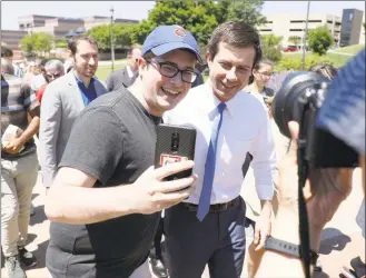  ?? Charlie Neibergall / Associated Press ?? Democratic presidenti­al candidate Pete Buttigieg, right, poses for a selfie during the Capital City Pride Fest in Des Moines, Iowa, on Saturday.