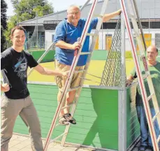  ?? FOTO: SABINE RÖSCH ?? Timo Heißel, Uwe Mühlbauer und Erwin Junker vom TSV Gammerting­en (von links) ersetzen die alten Netze beim Minispielf­eld hinter der Gammerting­er Alb-Lauchert Sport- und Schwimmhal­le.