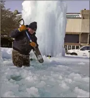  ?? LM OTERO ?? City of Richardson worker Kaleb Love breaks ice on a frozen fountain Tuesday, Feb. 16, 2021, in Richardson, Texas. Temperatur­es dropped into the single digits as snow shut down air travel and grocery stores.
