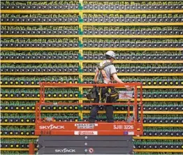  ?? LARS HAGBERG AFP VIA GETTY IMAGES ?? A technician inspects the backside of Bitcoin mining at Bitfarms in Saint Hyacinthe, Quebec. The cryptocurr­ency’s market value is soaring.